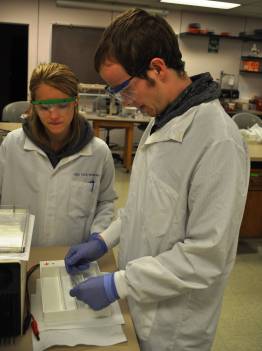 Two students in lab coats and goggles