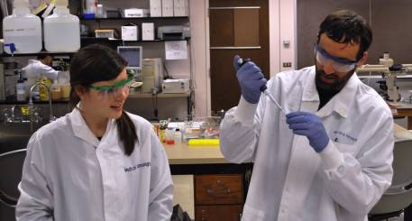 Student and faculty member in lab coats