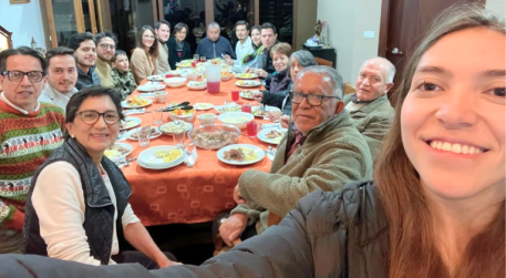 Paz pictured with a group of people sitting at a table with food.